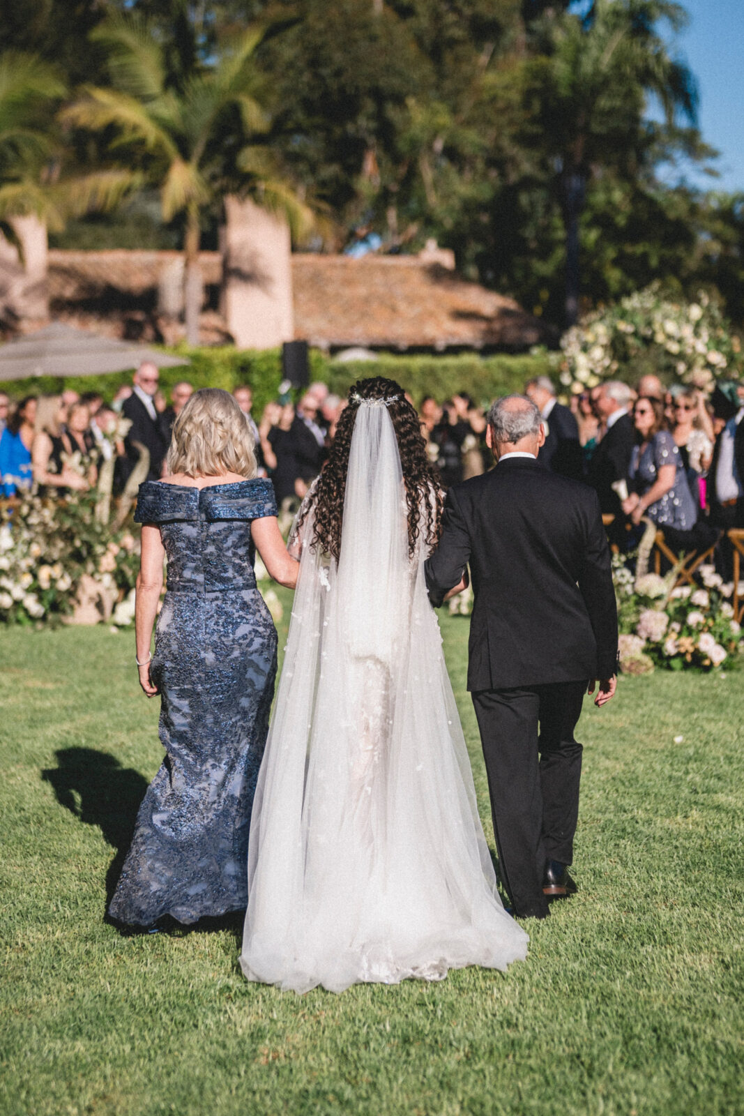 bride walking the aisle with her parents