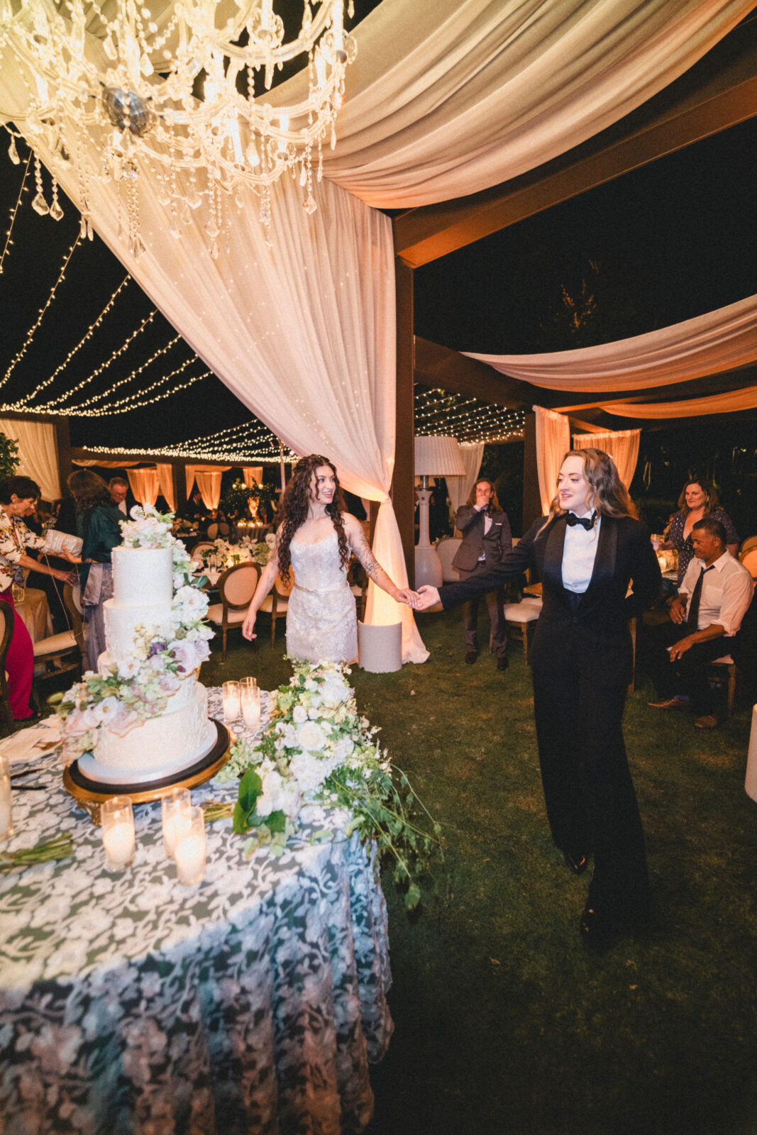 couple walking towards the wedding cake