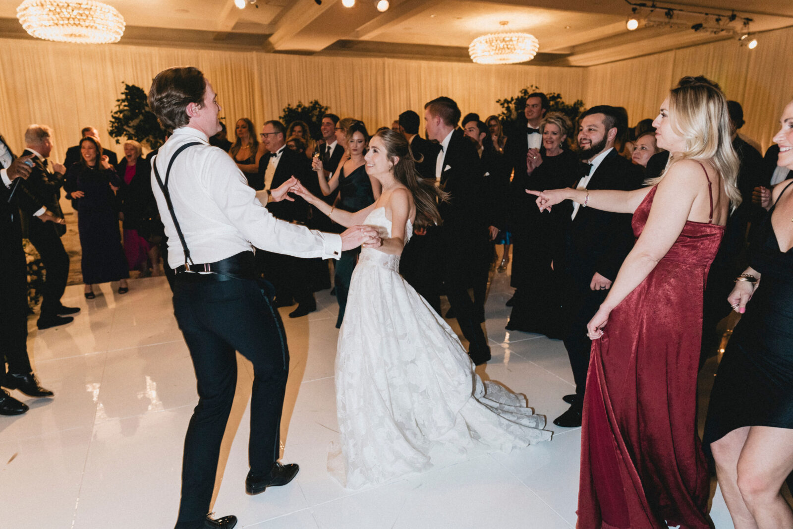 bride and groom dancing with family and friends