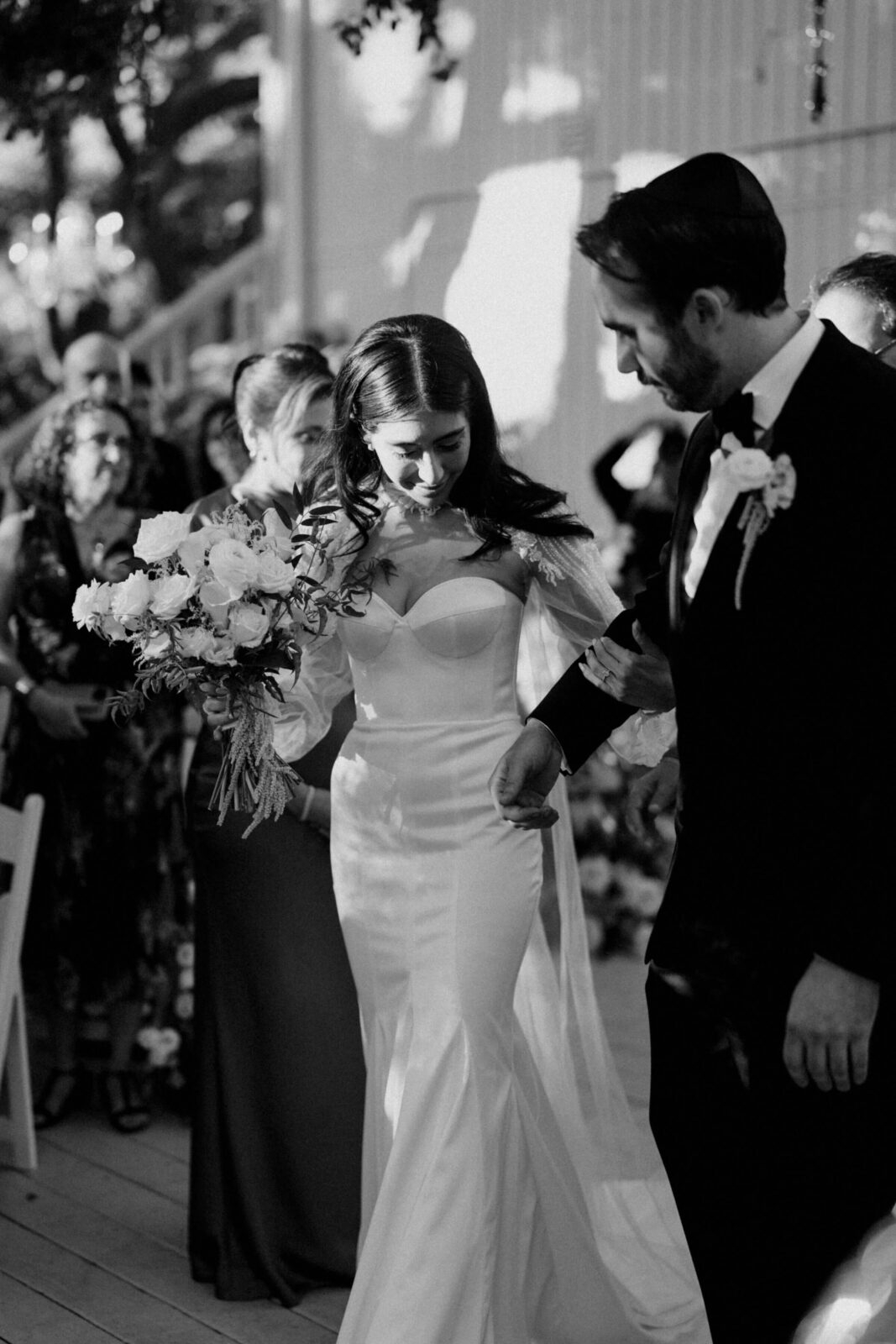 black and white photo bride and groom walking on the aisle