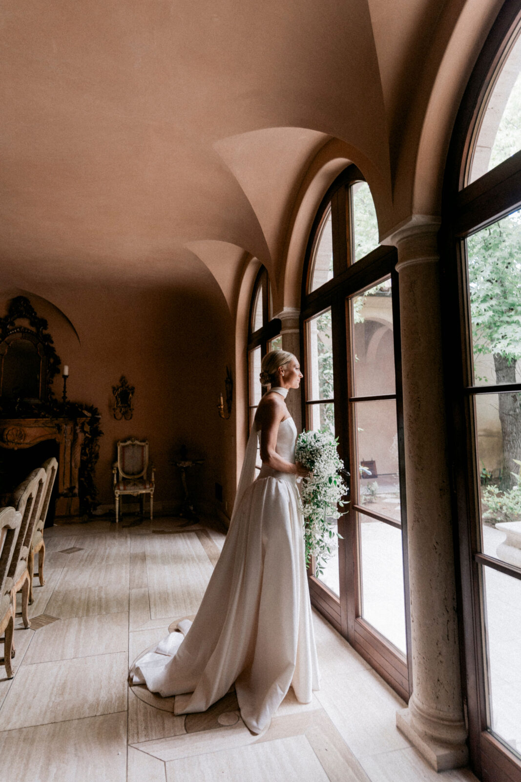 Bride in white gown looking outside