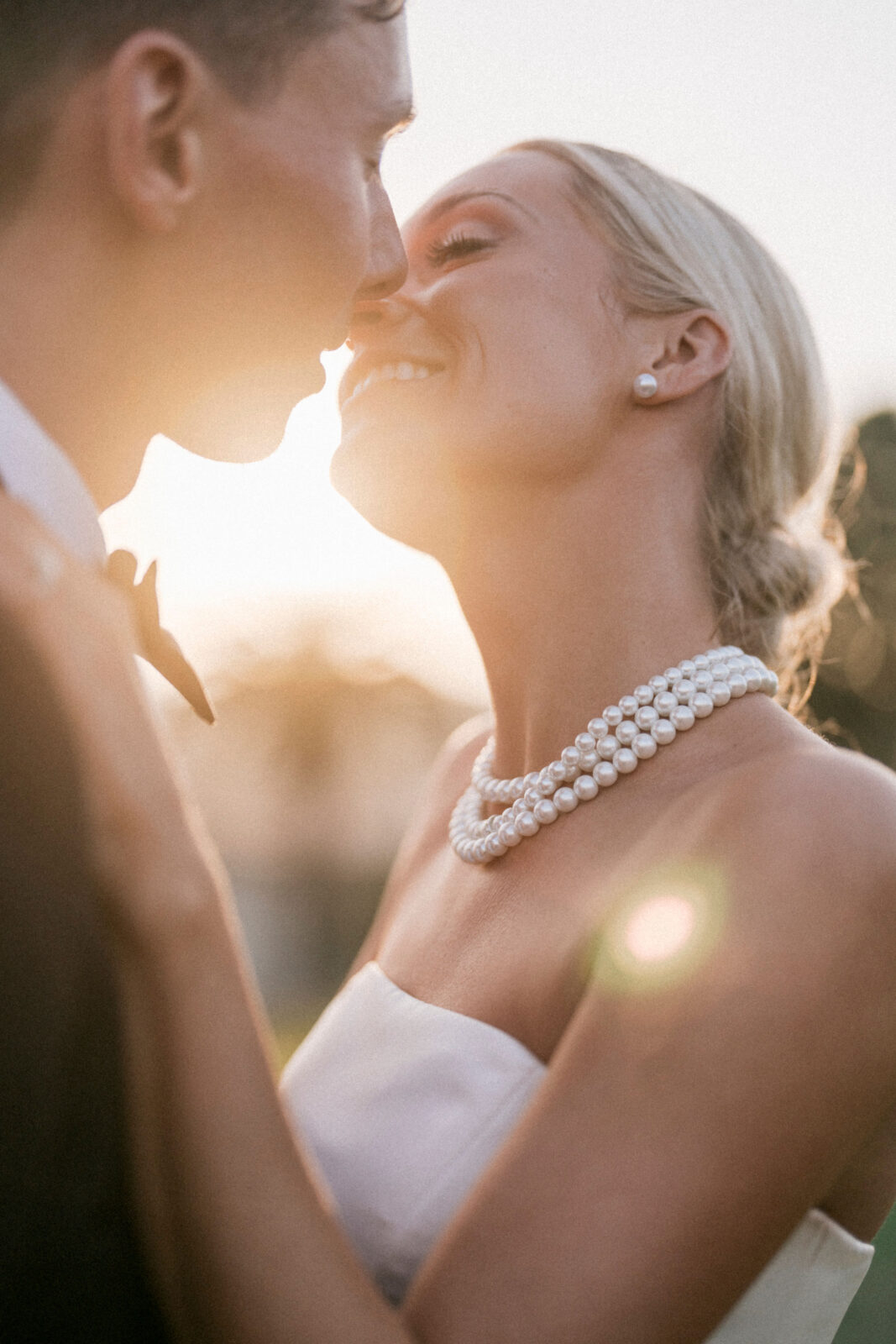 Bride and Groom kissing as the sun sets