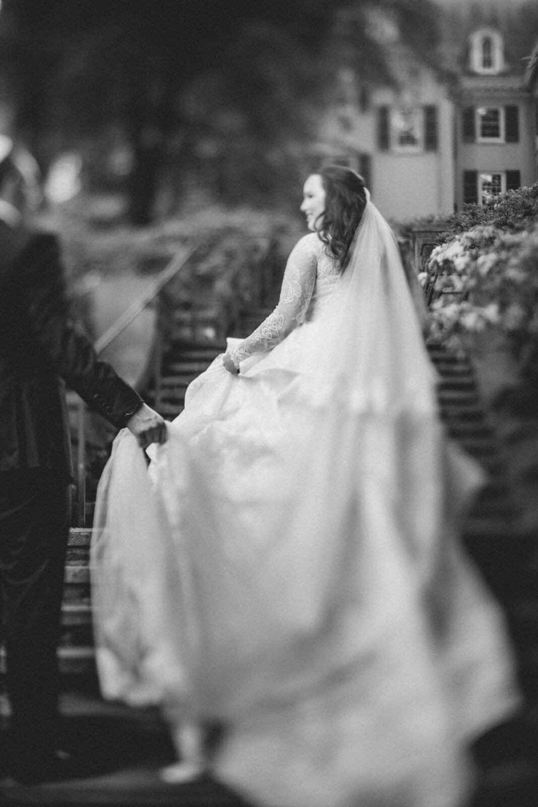 Black and white portrait of bride and groom walking at Winterthur Gardens