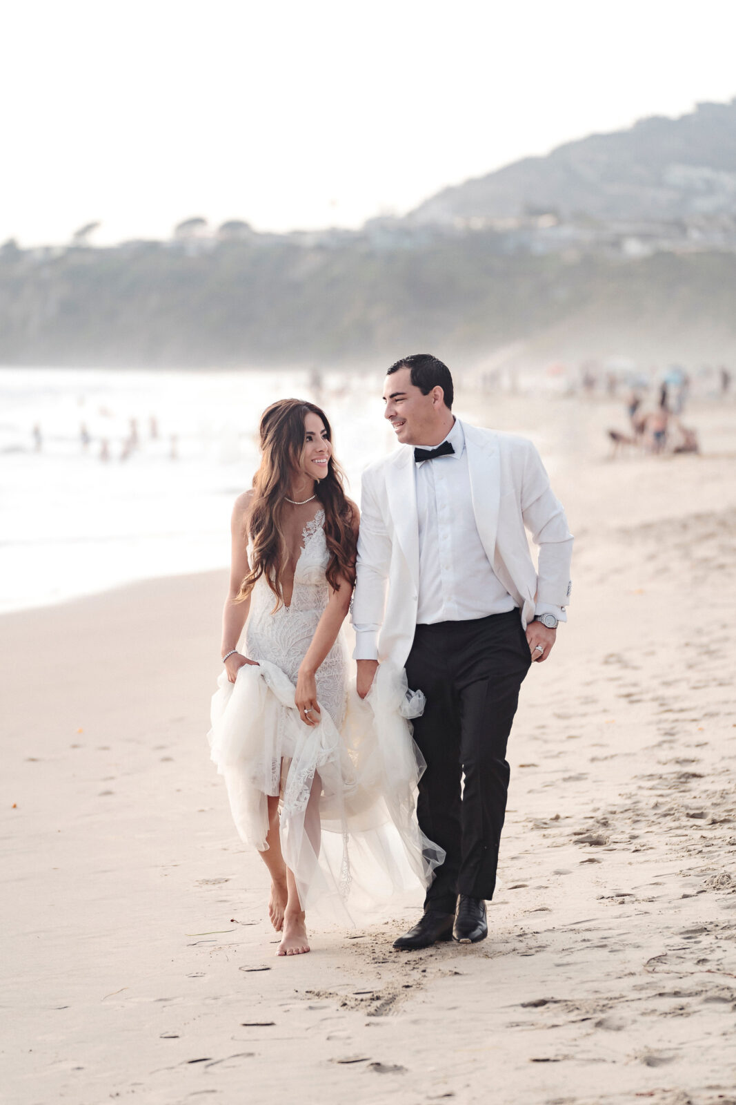 bride and groom walking on the shore