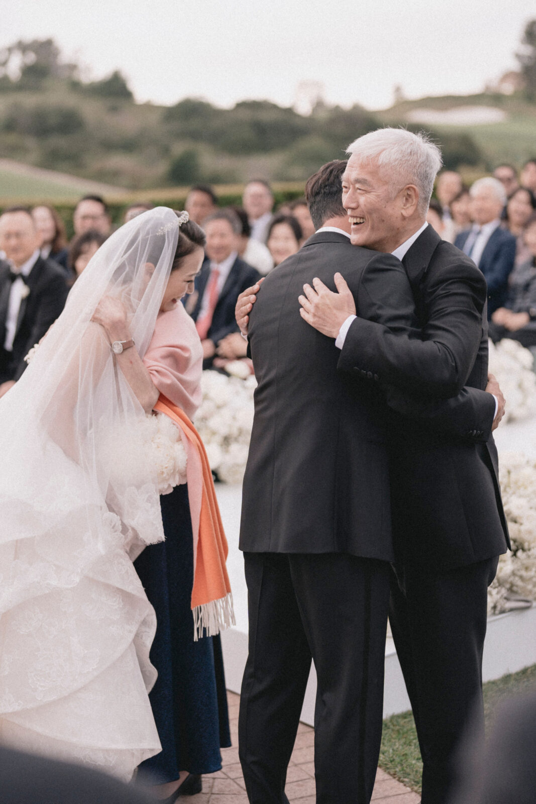 bride and groom with parents at the end of the aisle