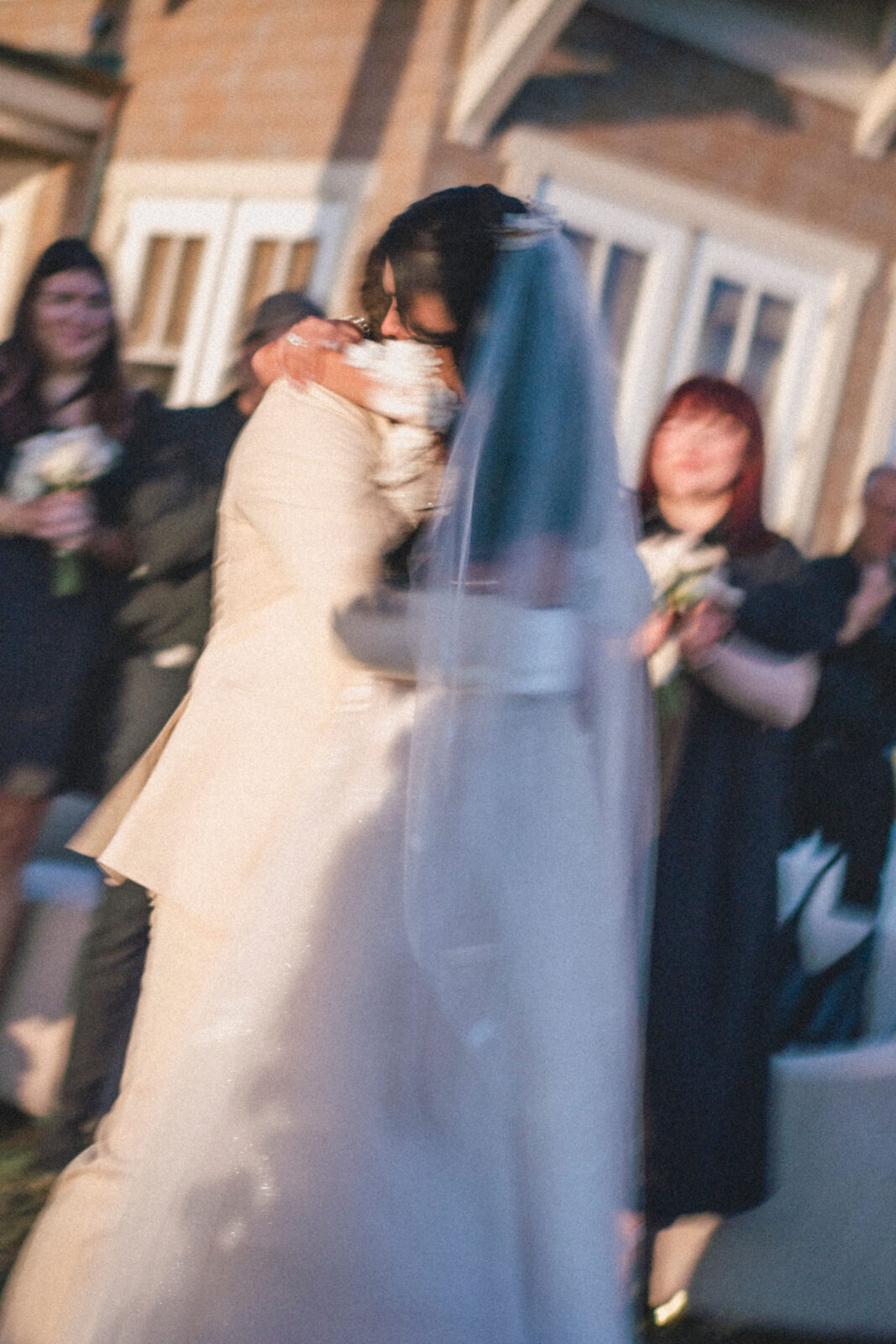 bride and groom hugging each other after ceremony with friends